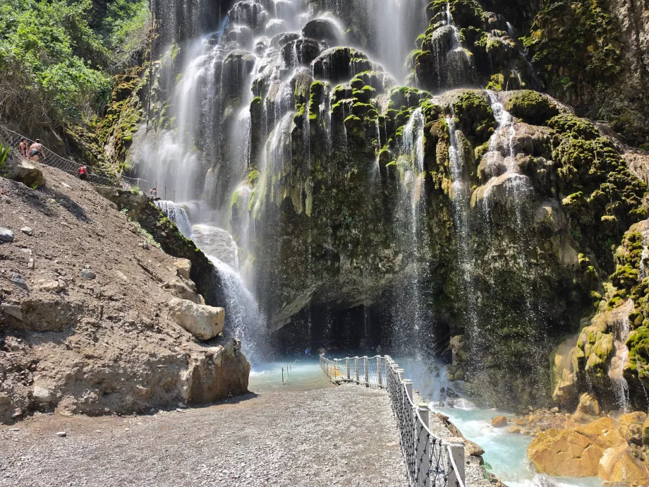 Wasserfall und Eingang zu einer großen offenen Höhle