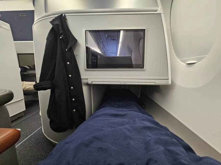 Auf einem ausklappbaren Sitz liegend